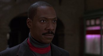 Movie still from “Nutty Professor II: The Klumps” (2000), directed by Peter Segal – A person wearing a suit and tie; Close Up shot, Over the shoulder angle