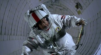 Movie still from “Nutty Professor II: The Klumps” (2000), directed by Peter Segal – A man in a spacesuit in an enclosed space; Medium shot, Low angle