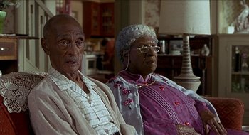 Movie still from “Nutty Professor II: The Klumps” (2000), directed by Peter Segal – A couple of people that are sitting on a couch; Close Up shot, High angle