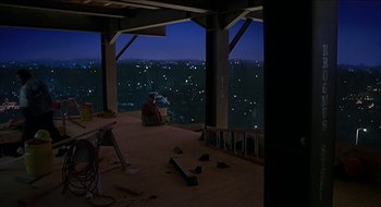 Movie still from “Nutty Professor II: The Klumps” (2000), directed by Peter Segal – A man sitting in a chair in a room with a view of a city; Extreme Wide shot, High angle