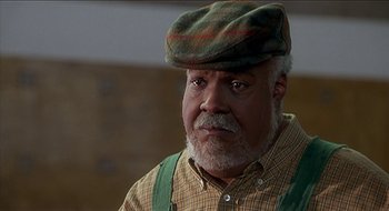 Movie still from “Nutty Professor II: The Klumps” (2000), directed by Peter Segal – An older man wearing a green hat and a plaid shirt; Close Up shot, Low angle