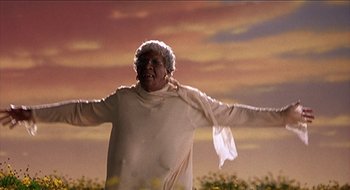Movie still from “Nutty Professor II: The Klumps” (2000), directed by Peter Segal – An older woman standing in a field with her arms outstretched; Medium shot, Low angle