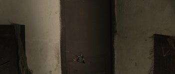 Movie still from “OSS 117: Cairo, Nest of Spies” (2006), directed by Michel Hazanavicius – The door of a room with a hole in the wall; Extreme Close Up shot, High angle