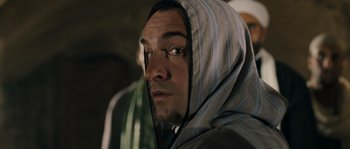 Movie still from “OSS 117: Cairo, Nest of Spies” (2006), directed by Michel Hazanavicius – A person wearing a hooded jacket; Close Up shot, Over the shoulder angle