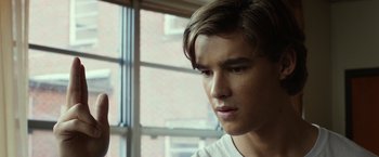 Movie still from “Oculus” (2013), directed by Mike Flanagan – A young man looking out of a window; Close Up shot, Over the shoulder angle