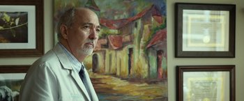 Movie still from “Oculus” (2013), directed by Mike Flanagan – An older man standing in front of a painting; Medium shot, Low angle