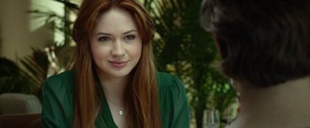 Movie still from “Oculus” (2013), directed by Mike Flanagan – A beautiful young lady with long red hair and wearing a green shirt; Close Up shot, Over the shoulder angle