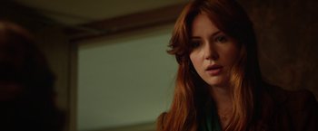 Movie still from “Oculus” (2013), directed by Mike Flanagan – A woman with long red hair looking at the camera; Close Up shot, Over the shoulder angle