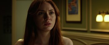 Movie still from “Oculus” (2013), directed by Mike Flanagan – A beautiful woman with red hair looking at the camera; Close Up shot, Over the shoulder angle