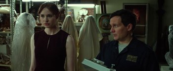 Movie still from “Oculus” (2013), directed by Mike Flanagan – A man and a woman are looking at each other in a room; Medium shot, Over the shoulder angle