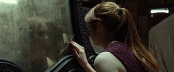 Movie still from “Oculus” (2013), directed by Mike Flanagan – A woman in a purple dress looking into a window; Close Up shot, Over the shoulder angle