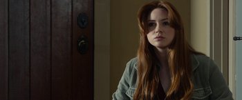 Movie still from “Oculus” (2013), directed by Mike Flanagan – A beautiful young lady with long red hair; Close Up shot, Over the shoulder angle