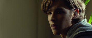 Movie still from “Oculus” (2013), directed by Mike Flanagan – A young man's face in the dark; Close Up shot, Low angle