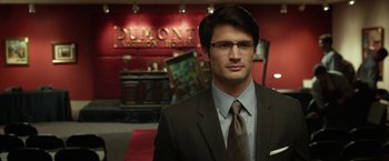 Movie still from “Oculus” (2013), directed by Mike Flanagan – A man in a suit and tie standing in front of a hotel lobby; Close Up shot, Over the shoulder angle