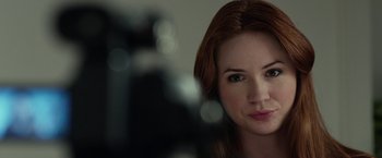 Movie still from “Oculus” (2013), directed by Mike Flanagan – A woman's face in front of a camera; Close Up shot, Over the shoulder angle