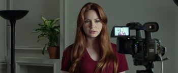 Movie still from “Oculus” (2013), directed by Mike Flanagan – A beautiful young woman with long , red hair; Close Up shot, Over the shoulder angle
