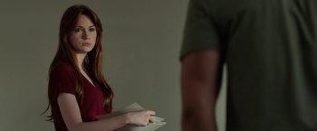 Movie still from “Oculus” (2013), directed by Mike Flanagan – A woman holding a piece of paper in front of a man; Medium shot, Over the shoulder angle
