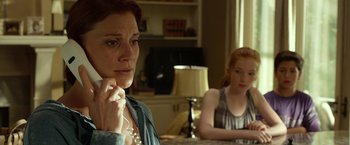 Movie still from “Oculus” (2013), directed by Mike Flanagan – A woman sitting next to another woman at a table; Close Up shot, Over the shoulder angle