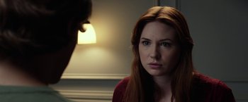 Movie still from “Oculus” (2013), directed by Mike Flanagan – A woman with red hair stares at the camera; Close Up shot, Over the shoulder angle