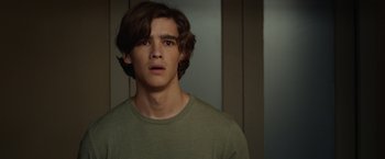 Movie still from “Oculus” (2013), directed by Mike Flanagan – A man with long hair and a green t - shirt; Close Up shot, Over the shoulder angle