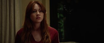 Movie still from “Oculus” (2013), directed by Mike Flanagan – A woman with long red hair sitting in a living room; Close Up shot, Over the shoulder angle