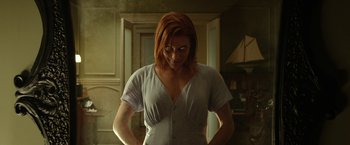 Movie still from “Oculus” (2013), directed by Mike Flanagan – A woman with red hair standing in front of a door; Medium shot, Low angle