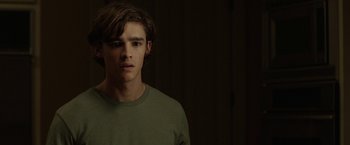 Movie still from “Oculus” (2013), directed by Mike Flanagan – A young man in a green shirt is looking at the camera; Close Up shot, Over the shoulder angle