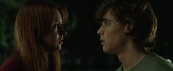 Movie still from “Oculus” (2013), directed by Mike Flanagan – A man and a woman face to face in the dark; Close Up shot, Low angle