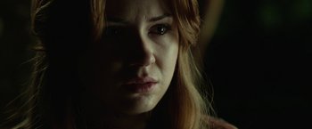Movie still from “Oculus” (2013), directed by Mike Flanagan – A woman's face in the dark; Close Up shot, Over the shoulder angle