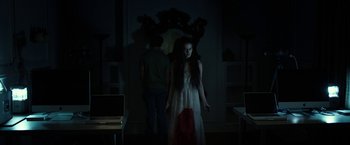 Movie still from “Oculus” (2013), directed by Mike Flanagan – A woman standing in front of a man in a room; Wide shot, Low angle