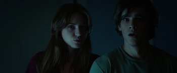 Movie still from “Oculus” (2013), directed by Mike Flanagan – A woman standing next to a man in the dark; Close Up shot, Low angle