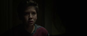 Movie still from “Oculus” (2013), directed by Mike Flanagan – A young boy is staring into the camera; Close Up shot, Over the shoulder angle