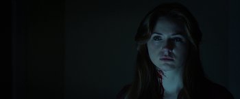 Movie still from “Oculus” (2013), directed by Mike Flanagan – A woman with a blood covered face in a dark room; Close Up shot, Low angle