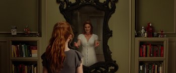 Movie still from “Oculus” (2013), directed by Mike Flanagan – A woman standing in front of a mirror; Medium shot, Over the shoulder angle
