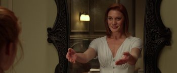 Movie still from “Oculus” (2013), directed by Mike Flanagan – A woman in a white dress is standing in front of a mirror; Medium shot, Over the shoulder angle