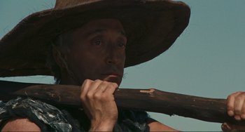 Movie still from “Oedipus Rex” (1967), directed by Pier Paolo Pasolini – A man with a straw hat is holding a stick; Close Up shot, Low angle