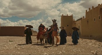 Movie still from “Oedipus Rex” (1967), directed by Pier Paolo Pasolini – A group of people standing on a dirt ground; Extreme Wide shot, Low angle
