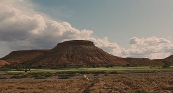 Movie still from “Oedipus Rex” (1967), directed by Pier Paolo Pasolini – A desert landscape with a mountain in the background; Extreme Wide shot, Low angle