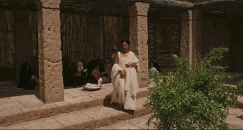 Movie still from “Oedipus Rex” (1967), directed by Pier Paolo Pasolini – A woman sitting on steps in front of a building; Wide shot, High angle