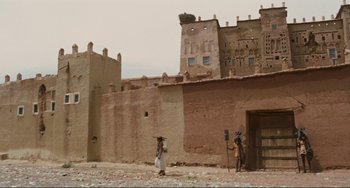 Movie still from “Oedipus Rex” (1967), directed by Pier Paolo Pasolini – A man and a woman standing in front of an old building; Extreme Wide shot, Low angle