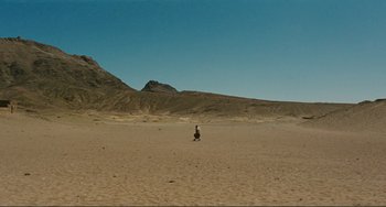 Movie still from “Oedipus Rex” (1967), directed by Pier Paolo Pasolini – A person standing in the middle of the desert; Extreme Wide shot, High angle