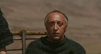 Movie still from “Oedipus Rex” (1967), directed by Pier Paolo Pasolini – A man wearing a sweater sitting in a chair; Close Up shot, High angle