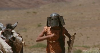 Movie still from “Oedipus Rex” (1967), directed by Pier Paolo Pasolini – A woman wearing a helmet and holding a sword; Medium shot, Low angle