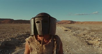 Movie still from “Oedipus Rex” (1967), directed by Pier Paolo Pasolini – A person wearing a helmet on the side of a road; Close Up shot, Low angle
