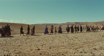 Movie still from “Oedipus Rex” (1967), directed by Pier Paolo Pasolini – A group of people walking across a dirt field; Extreme Wide shot, High angle