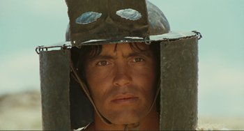 Movie still from “Oedipus Rex” (1967), directed by Pier Paolo Pasolini – A person wearing a helmet; Close Up shot, Low angle