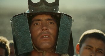 Movie still from “Oedipus Rex” (1967), directed by Pier Paolo Pasolini – A person wearing a metal helmet; Close Up shot, Low angle