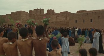 Movie still from “Oedipus Rex” (1967), directed by Pier Paolo Pasolini – A group of people standing in front of a brick wall; Extreme Wide shot, Over the shoulder angle