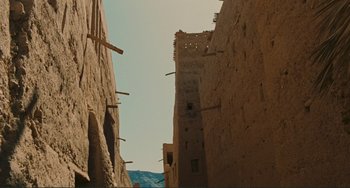 Movie still from “Oedipus Rex” (1967), directed by Pier Paolo Pasolini – An alley way with a tall building in the background; Extreme Wide shot, Low angle