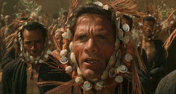 Movie still from “Oedipus Rex” (1967), directed by Pier Paolo Pasolini – A man with a bunch of seashells on his head; Close Up shot, Over the shoulder angle